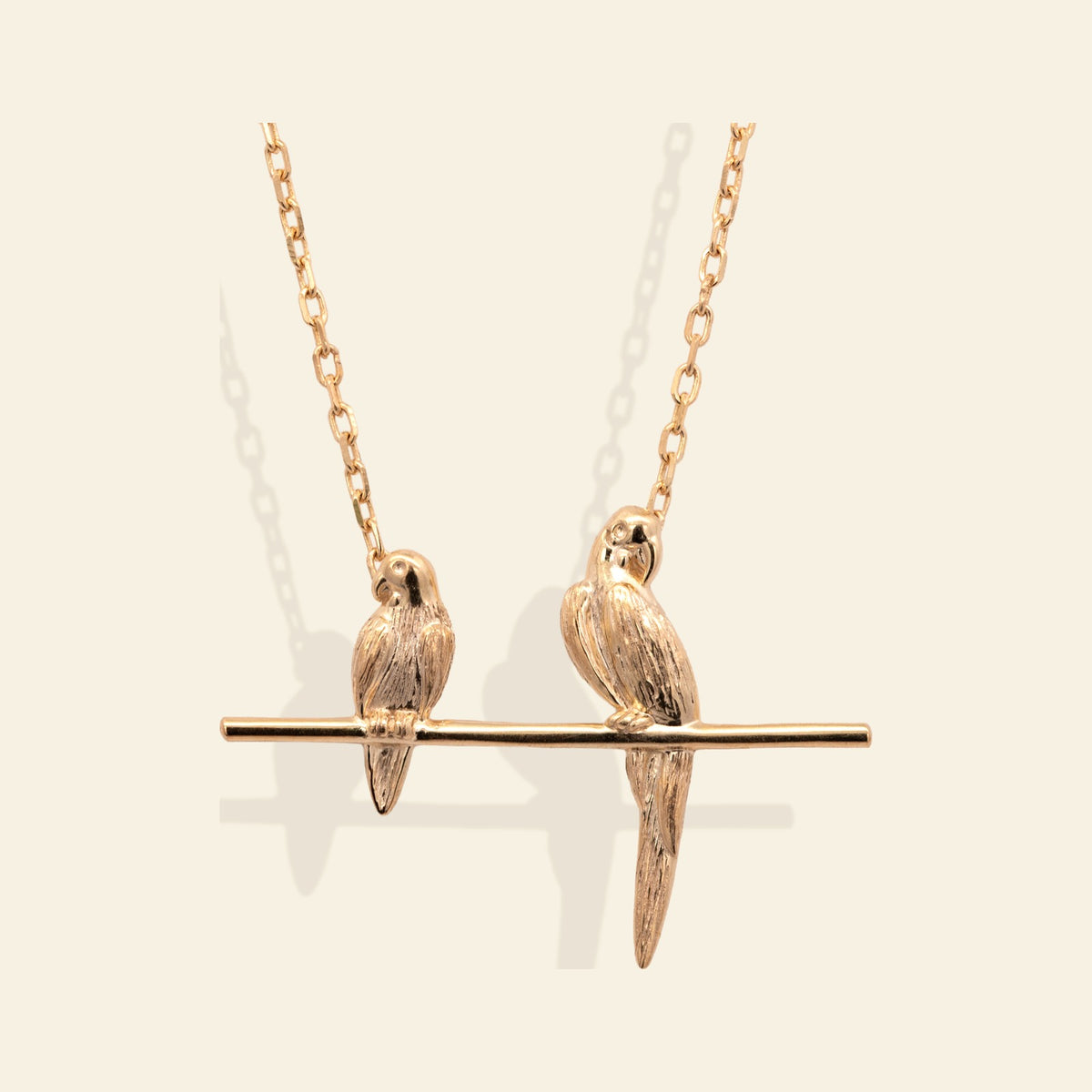 Junipurr x Frida Kahlo Bonitos in 14k yellow gold vermeil, two parrot pendant necklace, chain partially shown, front product view