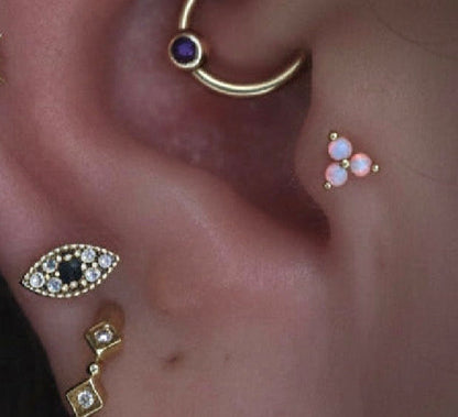 Junipurr Trinity opal cluster jewellery worn in a tragus piercing within a curated ear.