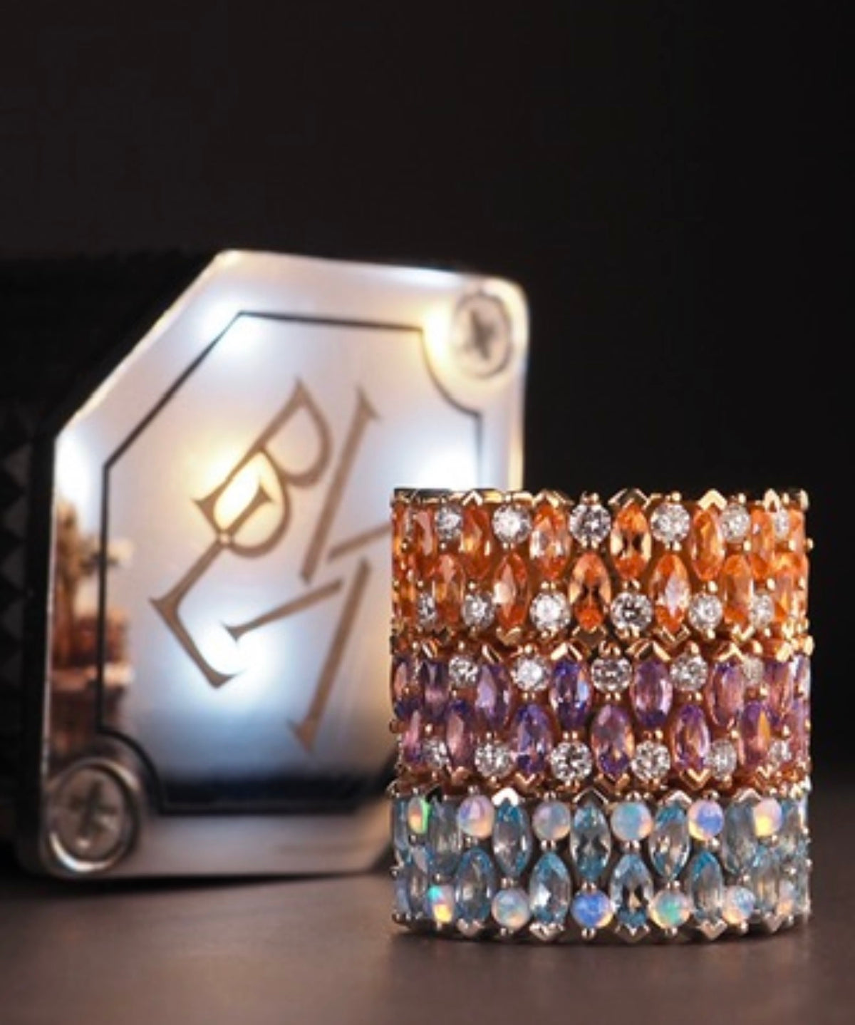 Three BVLA 2 Row Narrows 14k gold clicker rings shown in different gemstone combinations: yellow gold with Chatham Champagne Sapphire and diamonds, white gold with Swiss Blue Topaz and White Opal, and rose gold with lavender gemstones and diamonds.