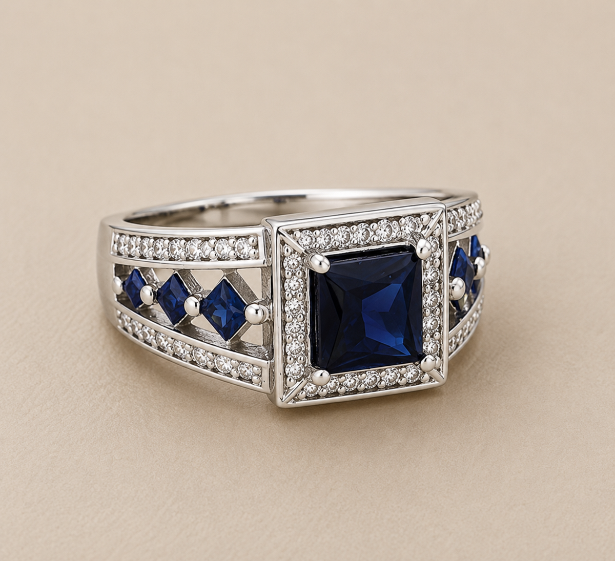 BVLA bespoke white gold ring featuring a princess-cut blue sapphire centre with a diamond halo, blue sapphire side stones and diamond pavé detailing in a handcrafted luxury custom engagement ring.