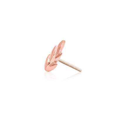 Solid rose gold leaf end positioned along a flat ear piercing for soft organic detail.