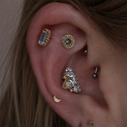 Junipurr Engraved Disk solid 14k gold star cartilage stud worn in a minimalist curated ear with complementary gold jewellery.