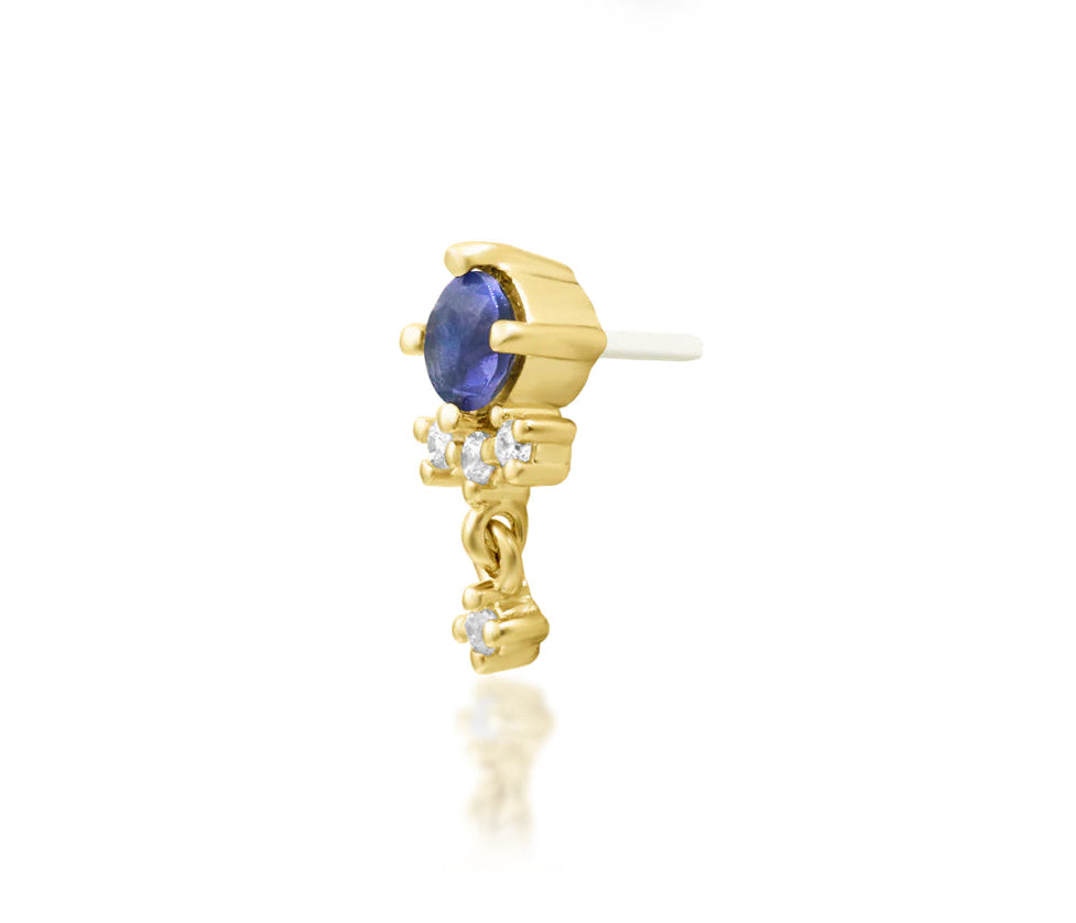 Off-front angled view of the Junipurr Jewellery Greta in yellow gold, showcasing the iolite centre stone and CZ dangle charm movement.