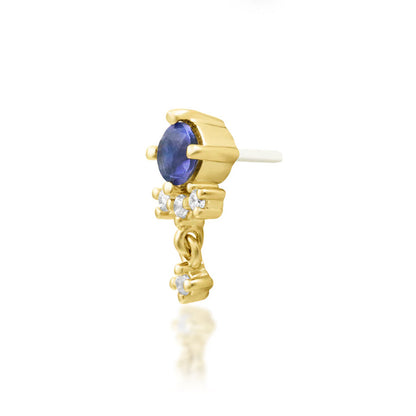 Off-front angled view of the Junipurr Jewellery Greta in yellow gold, showcasing the iolite centre stone and CZ dangle charm movement.