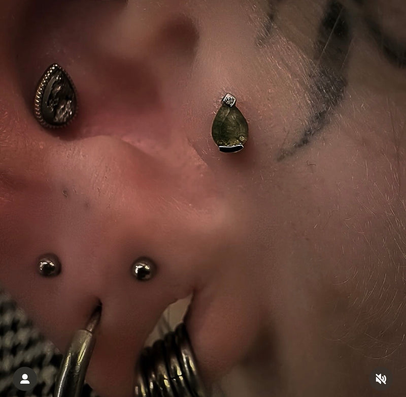 Luxury curated ear featuring Junipurr Moss Agate jewellery in the tragus with stacked lobe piercings in solid 14k gold.