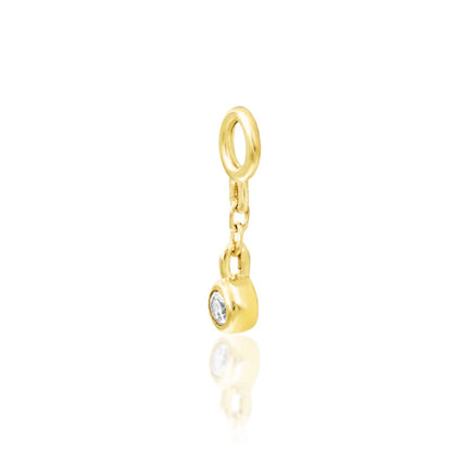 Angled view of Junipurr Olga solid 14k yellow gold chain charm with sparkling bezel-set cubic zirconia and elegant movement