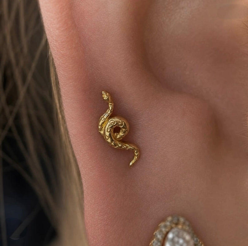 Close-up of a Junipurr textured snake stud in a mid helix piercing, crafted in solid yellow gold and styled as luxury cartilage jewellery.