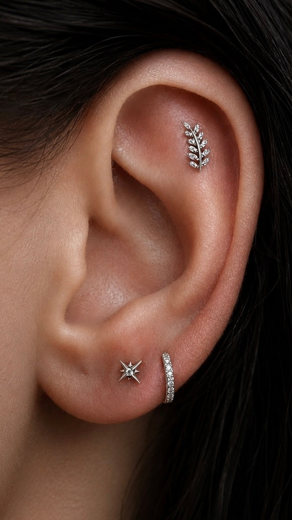 Curated ear featuring Junipurr Willow flat helix jewellery, Stella stud, Demi clicker ring and a polished 14k gold huggie hoop styled in a luxury ear stack.