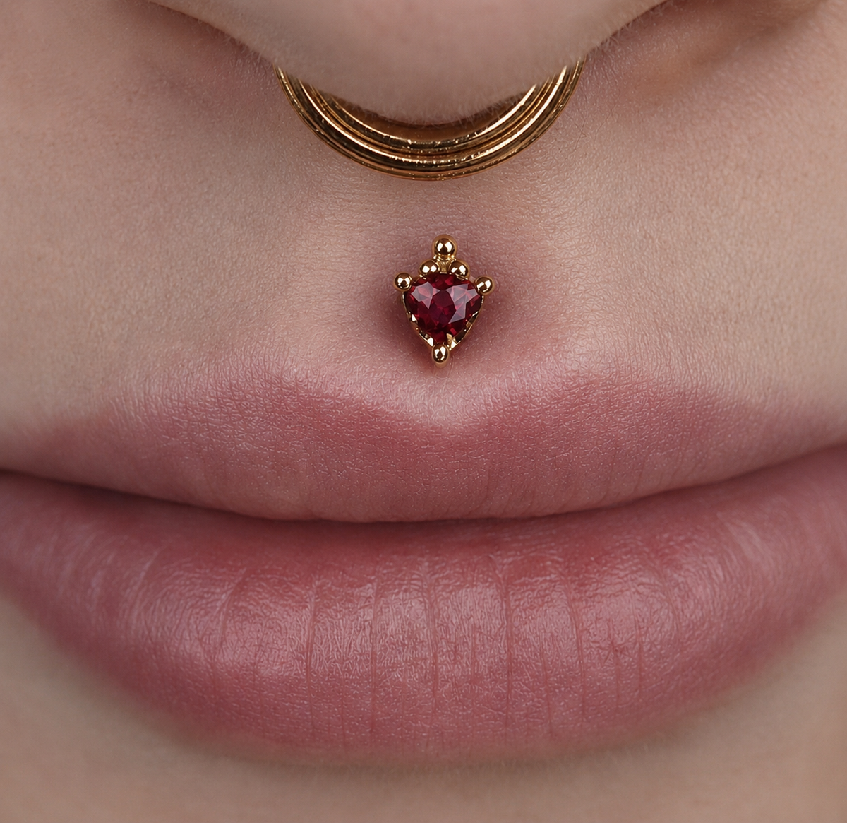 Close-up of the BVLA Timka philtrum stud in solid 14k yellow gold, styled as luxury Medusa piercing jewellery with an elegant decorative gold design.