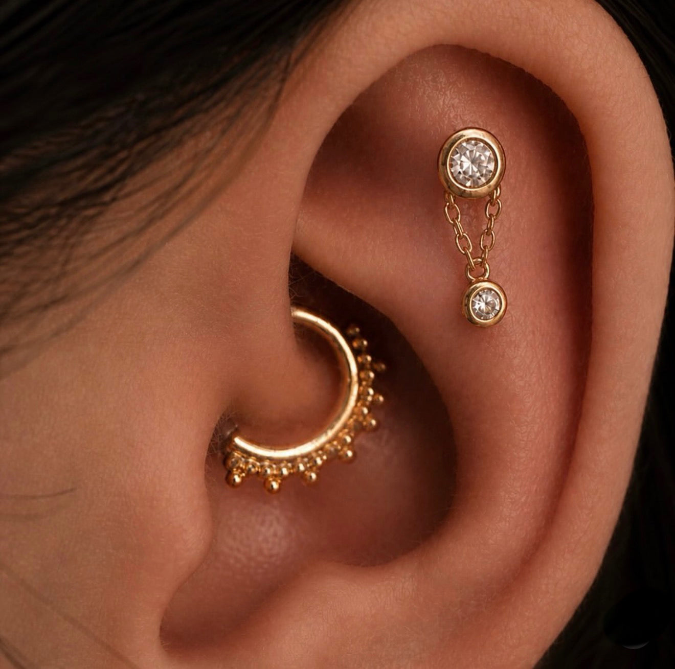 Curated ear styling with Junipurr Cora adding a delicate solid gold chain and sparkling CZ drop.