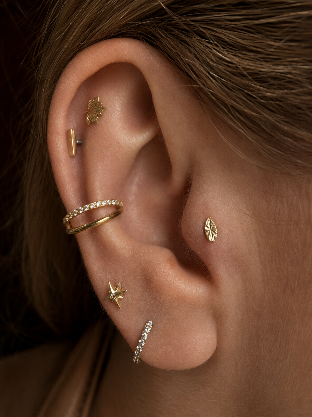 Curated ear styled with gold conch rings, helix and lobe piercing jewellery