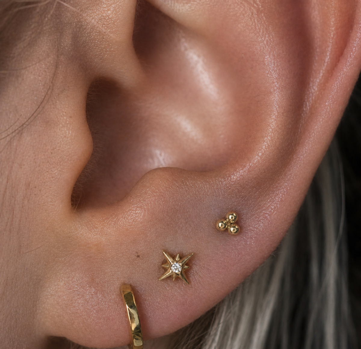 Lower ear showing lobe piercings with gold jewellery