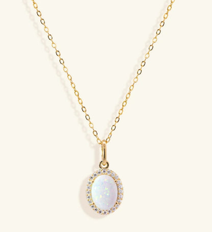 Junipurr Olenis gold necklace with a large oval opal and cubic zirconia halo, product view.