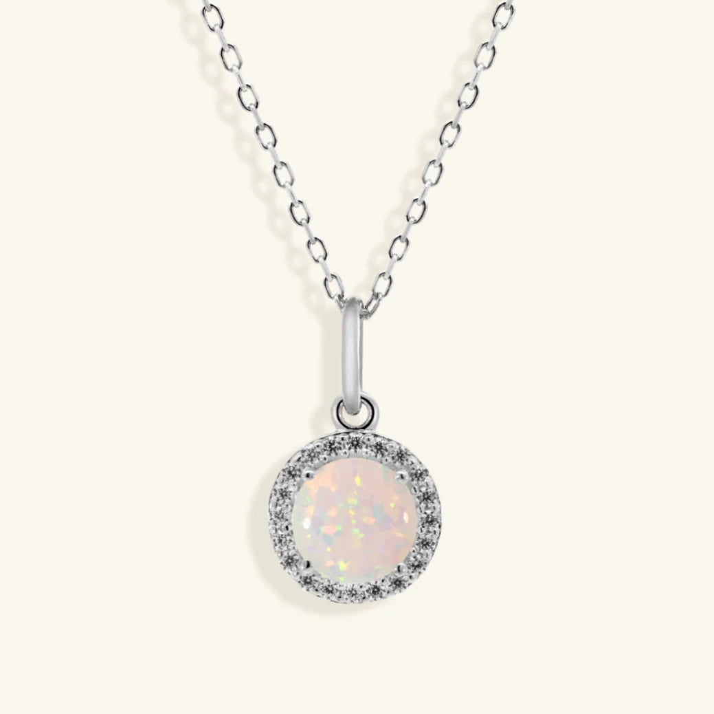 Junipurr Opalia gold necklace with a round opal and cubic zirconia halo, product view.