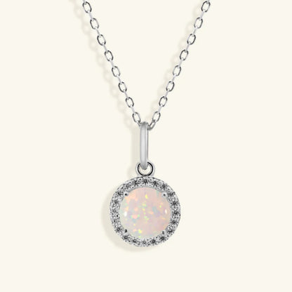 Junipurr Opalia gold necklace with a round opal and cubic zirconia halo, product view.