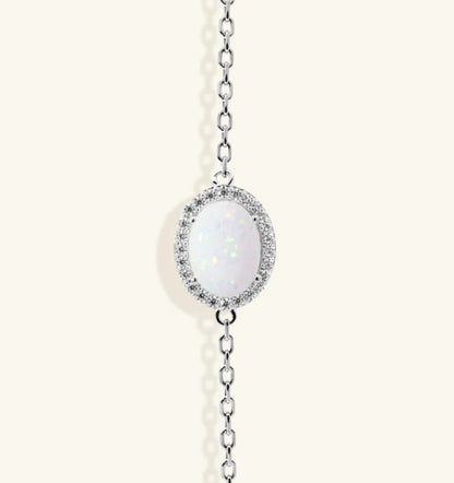 Junipurr Ulora adjustable gold bracelet with a synthetic opal and cubic zirconia halo, product view.