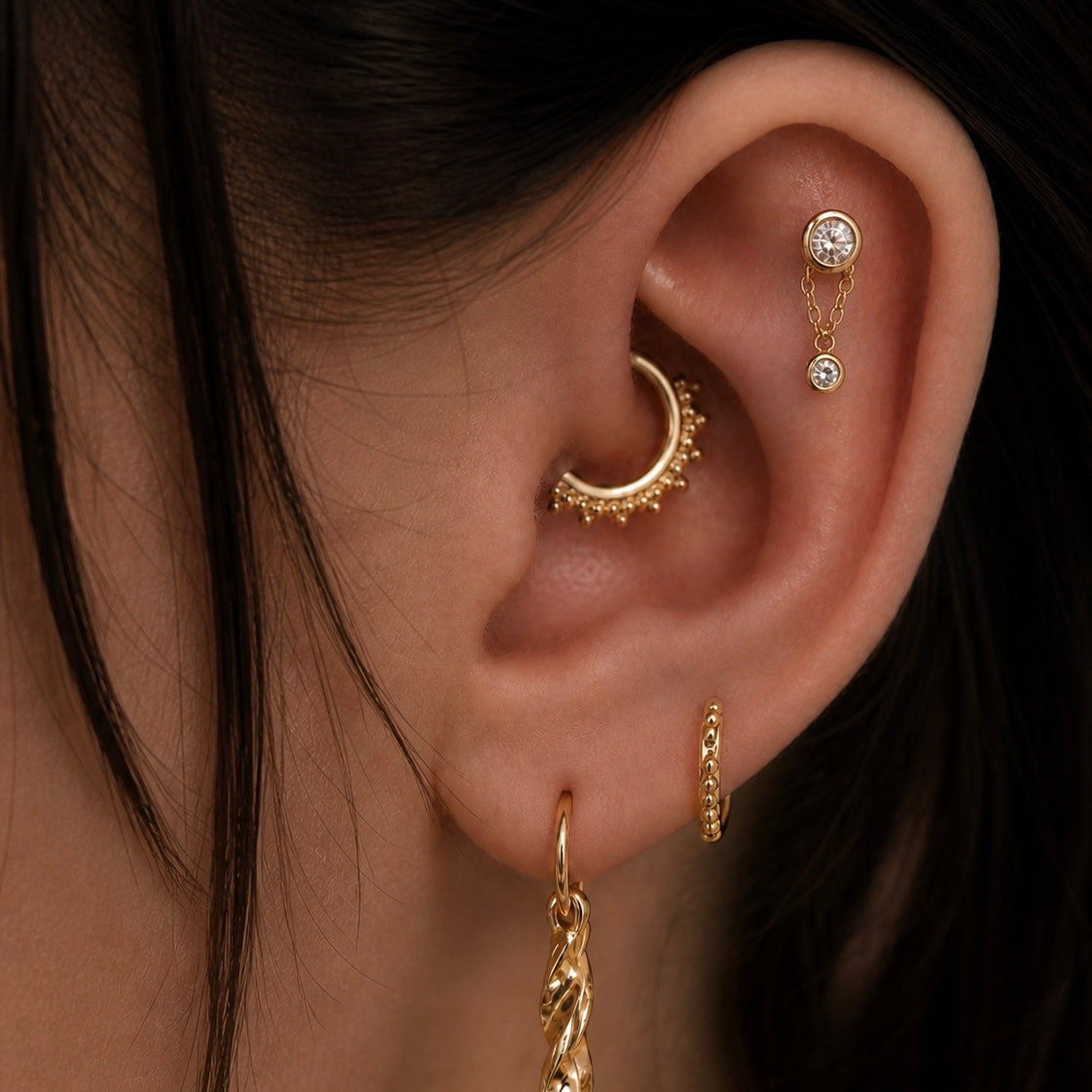 Curated ear styled with solid gold piercing jewellery
