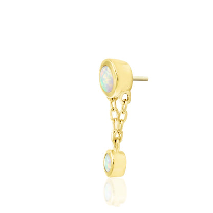 Opal cartilage earring in yellow gold, showing Junipurr Clara with a delicate chain and two white synthetic opals.