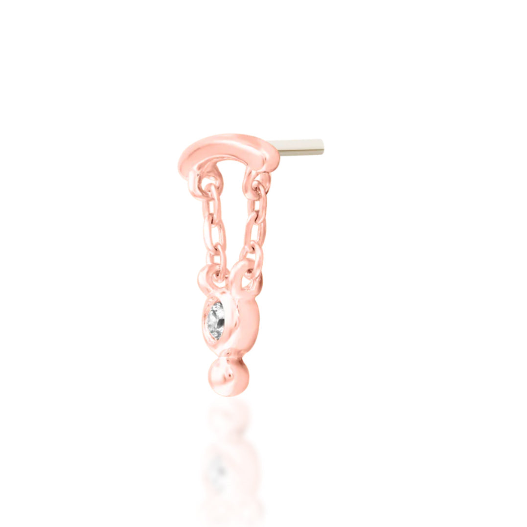 Statement cartilage earring in rose gold with an elongated solid-gold design and gemstone movement.